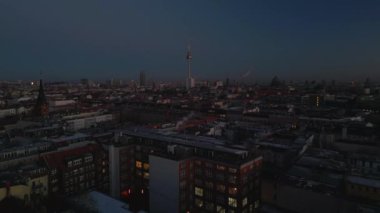 Akşam şehir manzarasının havadan yükselen görüntüleri. Gün batımında Metropolis 'teki binalar. Berlinli Fernsehturm gökyüzüne karşı. Berlin, Almanya.
