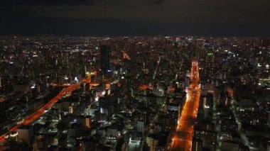 Geceleri Metropolis 'in havadan panoramik görüntüsü. Şehir merkezindeki yüksek binalar ve turuncu sokak ışıkları. Osaka, Japonya.