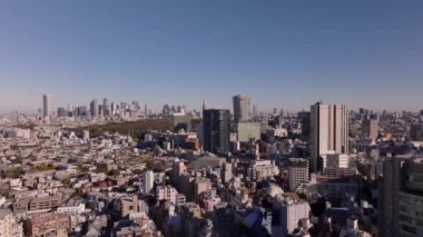 Yüksek binaları olan büyük bir şehrin havadan yükselen görüntüleri. Metropolis 'te altın saat. Tokyo, Japonya.