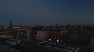 Şehirdeki binaların akşam görüntüleri. Yükselen görüntüler yerleşim yeri şehir merkezi ve arka plandaki uzun televizyon kulesini gösteriyor. Berlin, Almanya.