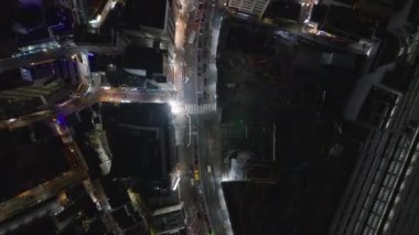 Geceleri şehir merkezinin kuş bakışı manzarası. Trafik ışıklarındaki araba kuyrukları. Kaldırımlarda yürüyen yayalar. Tokyo, Japonya.