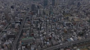 Şehir merkezindeki çok katlı binaların yüksek açılı manzarası. Caddede giden araçlar. Osaka, Japonya.