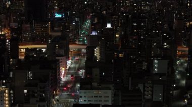 Gece şehrinin hava kaydırıcısı. Şehir mahallelerinde sokakları aydınlatan sokak lambaları. Konut ilçesindeki çok katlı apartmanlar. Osaka, Japonya.