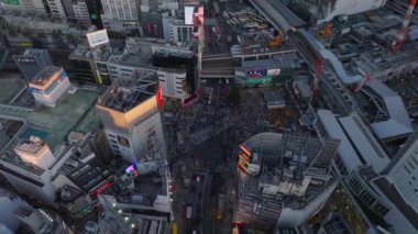 Shibuya Scramble Geçidi 'nin yüksek açılı görüntüsü. Kalabalık yaya geçidi popüler bir yer. Büyük video reklam ekranları. Tokyo, Japonya.