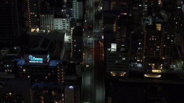 Şehir merkezindeki düz caddenin yüksek açılı görüntüsü. Yukari egilmek gece manzarasini ortaya çikar. Düşük ışık sahnesi. Osaka, Japonya.