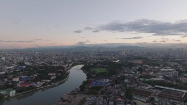 Metropolis 'in alacakaranlıktaki hava panoramik görüntüleri. Şehir merkezinden akan nehir. Manila, Filipinler.