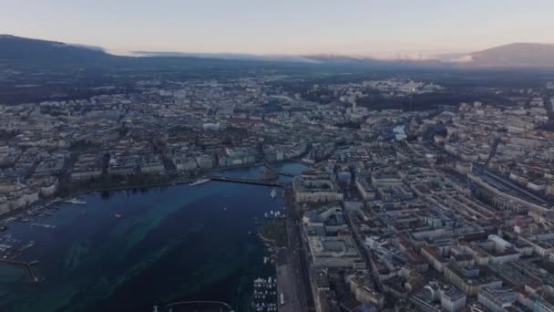 朝の街の上空を飛行する 湖と周辺の都市部のパノラマビュー ジュネーブ スイス — ストック動画
