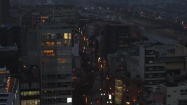 Akşam kentinde yüksek açılı cadde ve binalar var. Şehir merkezindeki çok katlı bir şehir. Kyoto, Japonya.