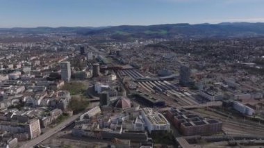 Şehrin havadan panoramik görüntüsü. Ulaşım altyapısı, şehir merkezindeki platformları ve binaları olan tren istasyonu. Basel, İsviçre.