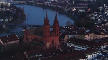 Karanlık çöktüğünde iki kuleli katedralin hava indirme görüntüleri. Şehir ve nehir arka planda. Basel, İsviçre.