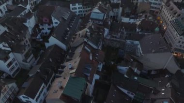 Tarihi şehir merkezindeki eski binaların çatılarının yüksek açılı görüntüsü. Güneş batarken gökyüzüne karşı şehri göster. Basel, İsviçre.