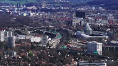 Şehirdeki ulaşım altyapısının hava görüntüleri. Yoğun otoyol ve çok kanallı demiryolu hattı futbol stadyumu ve yerleşim bölgesi etrafında dönüyor. Basel, İsviçre.