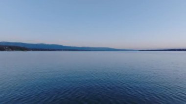 Gün doğmadan Geneva Gölü 'nün engin su yüzeyinin üzerinden uç. Doğanın sabah havadan görünüşü. Cenevre, İsviçre.