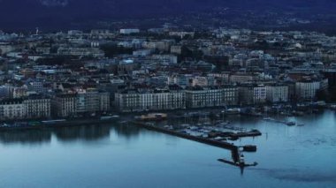 Rıhtımdaki çok katlı binaların havadan görüntüsü. Şehirdeki göl kıyısında demirli yelkenliler. Sabah sahnesi. Cenevre, İsviçre.