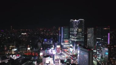 Shibuya Geçidi 'nin ve etrafındaki binaların hava görüntüsü geceye karışıyor. Akşam metropolü. Tokyo, Japonya.