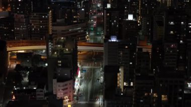 Gece şehrindeki caddelerin ve binaların yüksek açılı görüntüsü. Metropolis 'in yerleşim bölgesi. Osaka, Japonya.