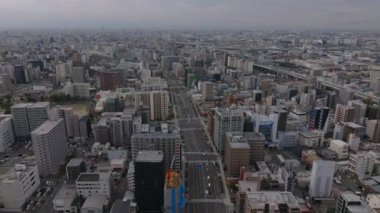Büyük şehrin hava panoramik görüntüleri. Şehir merkezindeki yoğun şehir gelişimine giden geniş bir çoklu yol. Osaka, Japonya.