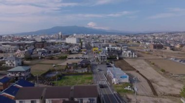 Şehrin yerleşim yerlerinde sokağın üstünde uç. Banliyölerdeki alçak binalar ve Fujisan dağının karla kaplı uzak köşeleri. Japonya.