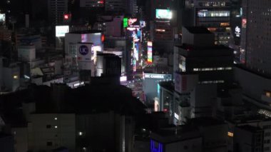 Geceleri modern şehirde binaların yüksek görüntüsü ve büyük LCD reklam ekranları. Ticari şehir ilçesi. Tokyo, Japonya.