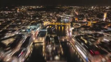 Gece şehrinin hava hiper yanılma görüntüsü. Aydınlanmış caddeler ve binalarla çevrili nehrin üzerinden geriye doğru uç. Cenevre Gölü 'nü Jet d Eau çeşmesiyle aydınlatmak. Cenevre, İsviçre.
