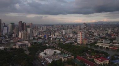 Alacakaranlıktaki Metropolis 'in havadan panoramik görüntüsü. Şehirde çeşitli şehirler var. Pasig Nehri kasabadan akıyor. Manila, Filipinler.