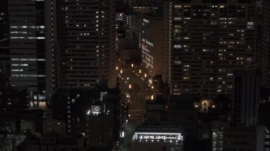 Gece konutlardaki yüksek binaların havadan yükselen görüntüleri. Metropolis 'te yaşıyor. Osaka, Japonya, 20 Ocak 2024