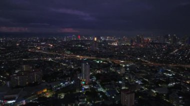 Metropolün havadan panoramik görüntüsü. Şehirdeki binaların ve sokakların üzerinden uç. Yoğun caddelerdeki araçlar ve modern şehir merkezindeki yüksek binalar. Manila, Filipinler.