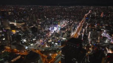 Dotonbori kentsel bölgesinin gece parlayan hava görüntüleri. Popüler turist ve gece hayatı bölgesi. Metropolün panoramik manzarası. Osaka, Japonya.