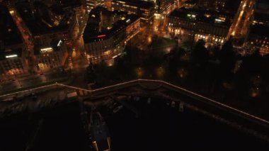 İnsansız hava aracı Genevas 'ı yakalıyor, geceleri şehir manzarasını aydınlatıyor, parlayan binalar sergiliyor ve çarpıcı bir hava manzarası ile sokakları sarmalıyor..