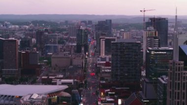 Nashville şehir merkezinin alacakaranlıktaki hava manzarası, aydınlık şehir manzarası, inşaat vinçleri ve gece hayatı Broadway sokak restoranlarının çatıları..