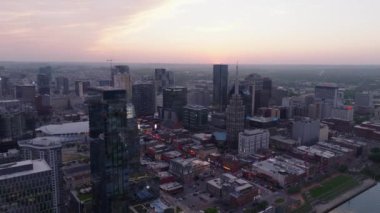 Gün batımında Nashville şehir merkezinin havadan görüntüsü. Şehir ışıkları, restoranları, barları ve barlarıyla canlı bir gökyüzü ve Broadway caddesine karşı modern gökdelenleri aydınlatıyor..