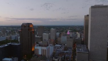 Akşam karanlığında New Orleans şehir merkezinin havadan görünüşü, parlayan gökdelenleri ve bu gece günbatımında hareketli atmosferi gösteriyor..