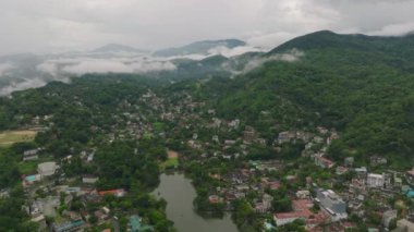 Kandy, Sri Lanka 'nın hava manzarası, yemyeşil manzaralar, sakin bir göl, ve sisli tepeler, doğal güzellikleri yansıtıyor..