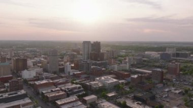 Birmingham 'ın hava görüntüsü, ABD şehir manzarası günbatımında öne çıkan binalar ve sıcak, parıldayan bir gökyüzü ile kentsel yerleşim.