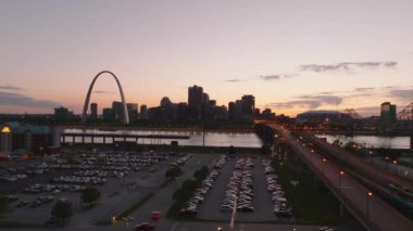 Gün batımında St. Louis 'in hava manzarası, sıcak ışık ile Mississippi Nehri boyunca ikonik geçit kemeri ve canlı şehir manzarasını sergiliyor..