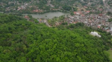 Kandy 'nin havadan görünüşü, yemyeşil Sri Lanka, dingin bir göl ve bir dağ zeminine karşı kentsel alan.