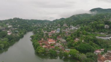 Kandy 'nin resimli şehrini keşfedin, Sri Lanka yukarıdan. Tarihi mimarinin, yemyeşil tepelerin ve huzurlu bir nehrin karışımına bakın..