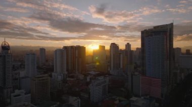 Gün batımında Manila 'nın gökyüzü manzarası. Altın saat ışığı gökdelenlere güzel bir parıltı saçar, pitoresk bir şehir manzarası yaratır.