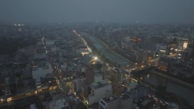 Gün batımında şehir bölgesindeki binaların ve sokakların hava yükselen görüntüleri. Akşam şehrinin panoramik manzarası ortaya çıkıyor. Kyoto, Japonya, 10 Şubat 2024