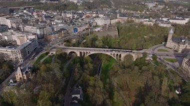 Lüksemburg şehrinin çarpıcı hava manzarası, tarihi köprüsü Pont Adolphe, yeşil parklar ve muhteşem mimarisi sergileniyor..