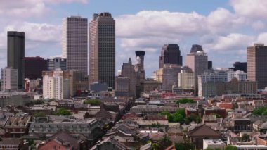 New Orleans 'ın modern ofis binalarının hava manzarası ikonik siluetini ve şehir merkezindeki mimarisini parçalı bulutlu bir gökyüzü altında gösteriyor..