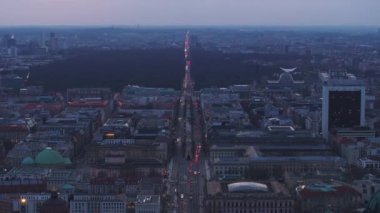 Berlins Unter den Linden Bulvarı 'nın ve Brandenburg Kapısı' nın alacakaranlıkta Tiergarten 'ın arka planında nefes kesici hava manzarası..