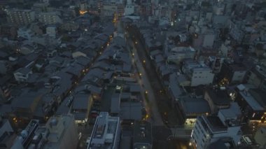 Şehir merkezindeki evlerin gece görüş açısı yüksek. Akşam şehrinin üzerinden uç. Kyoto, Japonya.