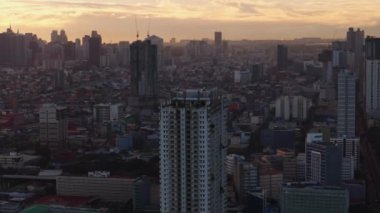 Günbatımında Manila 'nın dinamik şehir manzarası, çeşitli mimarisini ve hareketli şehir yaşamını ve özel bahçeli bir terası vurguluyor..
