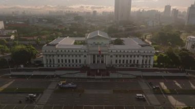 Manila 'daki Ulusal Güzel Sanatlar Müzesi' nin şafak vakti canlı şehir siluetine karşı tarihi yapısını vurguluyor ve Filipinler başkentinin güzelliğini gösteriyor..