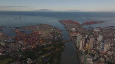 Manila Körfezi 'nin ve limanın çarpıcı hava manzarası konteynırlar, vinçler ve gemilerle mallarını bu büyük Asya altyapısına boşaltmak için bekliyor..