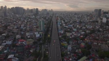 Alacakaranlıktaki Manilas şehir manzarası, simetrik mimari ve şehir silueti, kentsel kalkınma ve gayrimenkul konseptini gösteren hava manzarası.