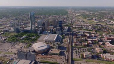 Gökdelenlerin, şehir planlarının ve güneşli bir günde yeşil manzaraların sergilendiği Oklahoma Citys şehir merkezinin hava manzarası. Oklahoma City, ABD, 10 Nisan 2024
