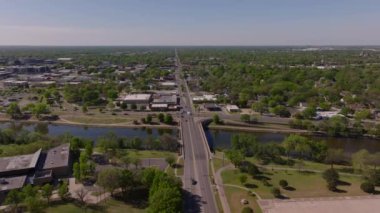 Nehir üzerinde bir köprü bulunan Wichitas şehir manzarası, yeşil ve kentsel gelişimle çevrili, kentsel manzaralar ve altyapı sergileniyor..