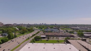 Temiz mavi gökyüzü altında, büyük yollar, yeşil alanlar ve kentsel yapılar gösteren, Kansas City 'nin ufuk çizgisine doğru ilerleyen pürüzsüz hava manzarası